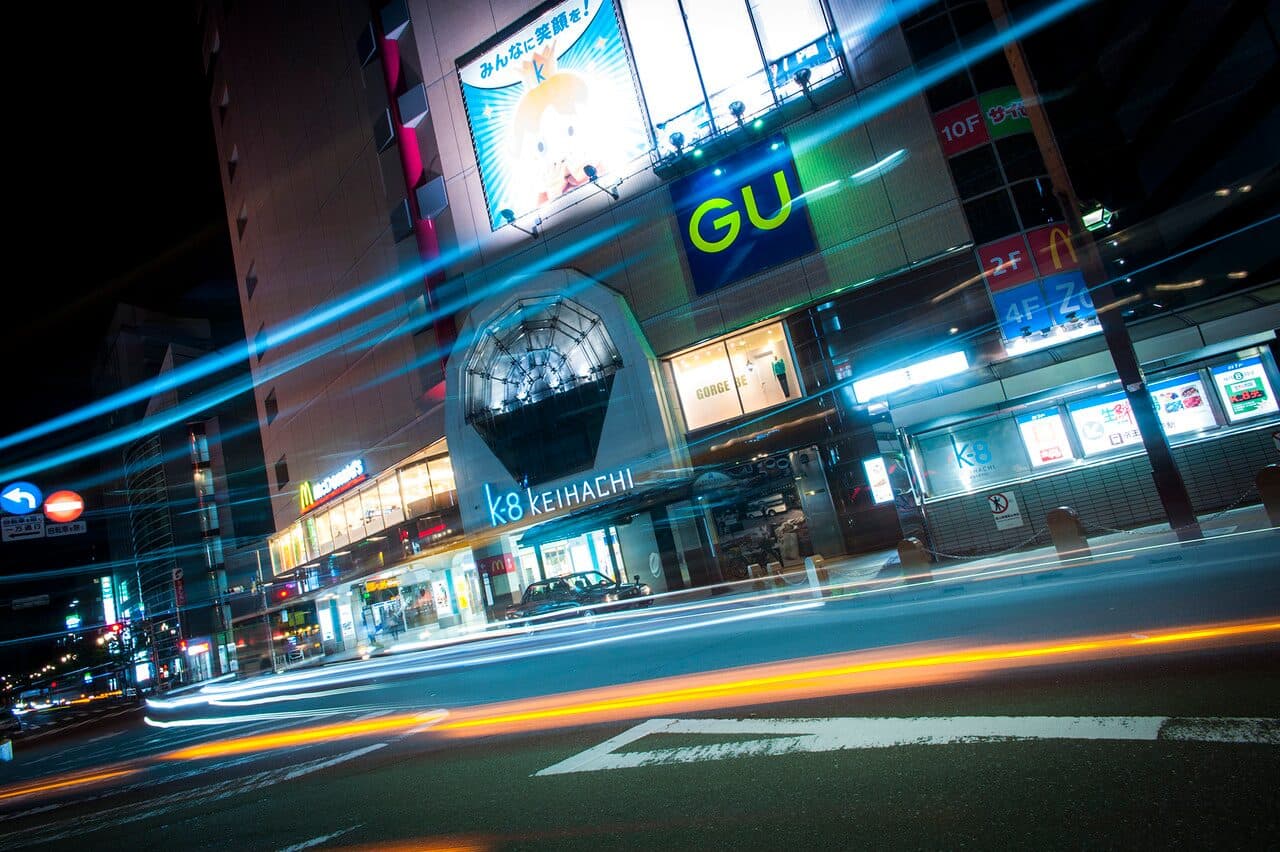 Light trails sweeping past the Keio Hachioji station building at night